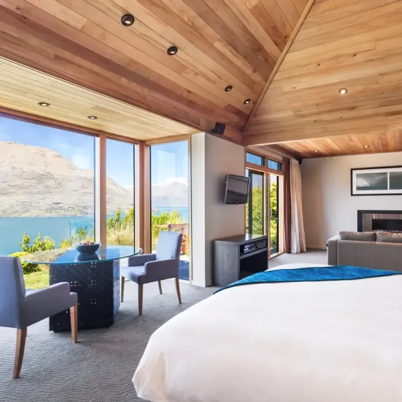 Deluxe room with king bed, schist stone feature wall and lake view
